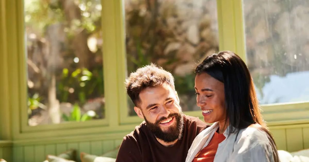 A couple smiling together as they plan their wedding budget